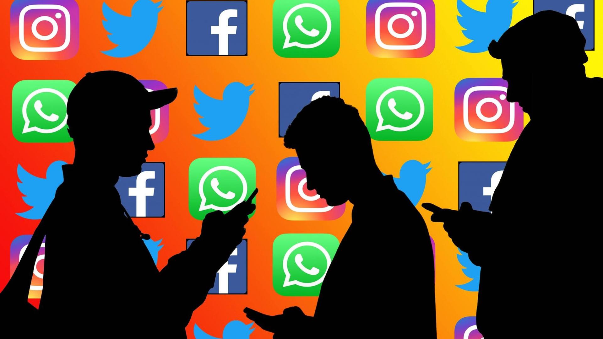 Silhouetten von Personen, die mit gesenktem Kopf auf den Bildschirm ihrer Smartphones schauen. Im Hintergrund die Logos von Facebook, Twitter, Whatsapp und Instagram. Silhouetten von Personen, die mit gesenktem Kopf auf den Bildschirm ihrer Smartphones schauen. Im Hintergrund die Logos von Facebook, Twitter, Whatsapp und Instagram.