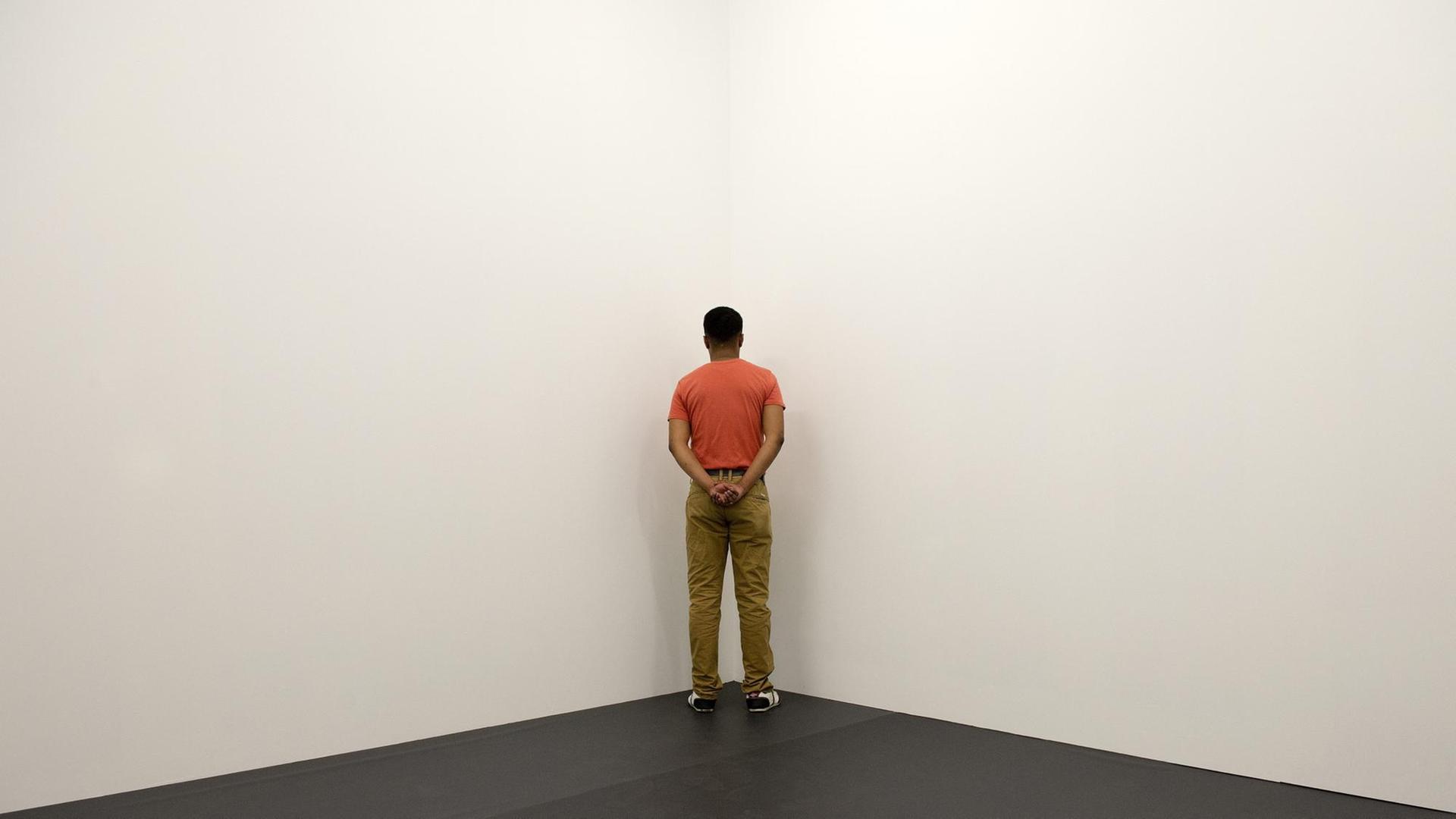 Die Arbeit 'Veterans of the Wars of Eritrea, Kosovo and Togo Facing the Corner' (2014) vom spanischen Künstler Santiago Sierra in der Ausstellung "14 Rooms", Basel, Juni 2014: Ein Kriegsveteran stellt sich reglos und stumm in die Ecke und kehrt sich dabei dem Publikum den Rücken Die Arbeit 'Veterans of the Wars of Eritrea, Kosovo and Togo Facing the Corner' (2014) vom spanischen Künstler Santiago Sierra in der Ausstellung "14 Rooms", Basel, Juni 2014: Ein Kriegsveteran stellt sich reglos und stumm in die Ecke und kehrt sich dabei dem Publikum den Rücken