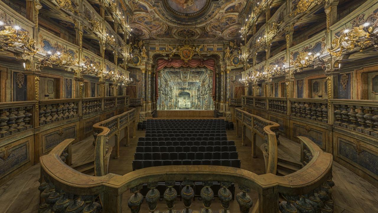 Blick in den barocken Zuschauerraum zur Bühne, die mit barockem Bühnenbild versehen ist. Blick in den barocken Zuschauerraum zur Bühne, die mit barockem Bühnenbild versehen ist.