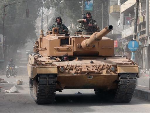 Ein türkischer Panzer fährt durch eine Straße in Afrin.