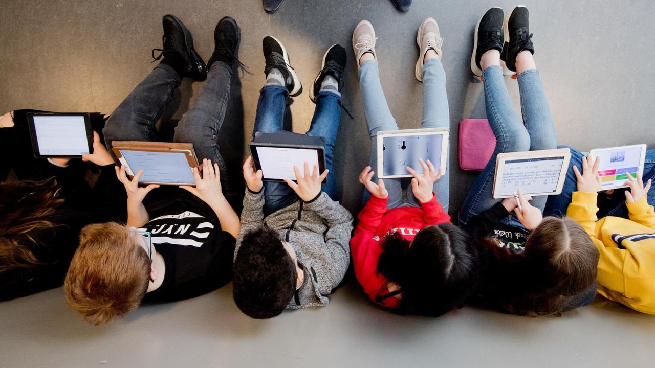 Schüler sitzen in einer Reihe und lernen mit Laptops. Schüler sitzen in einer Reihe und lernen mit Laptops.