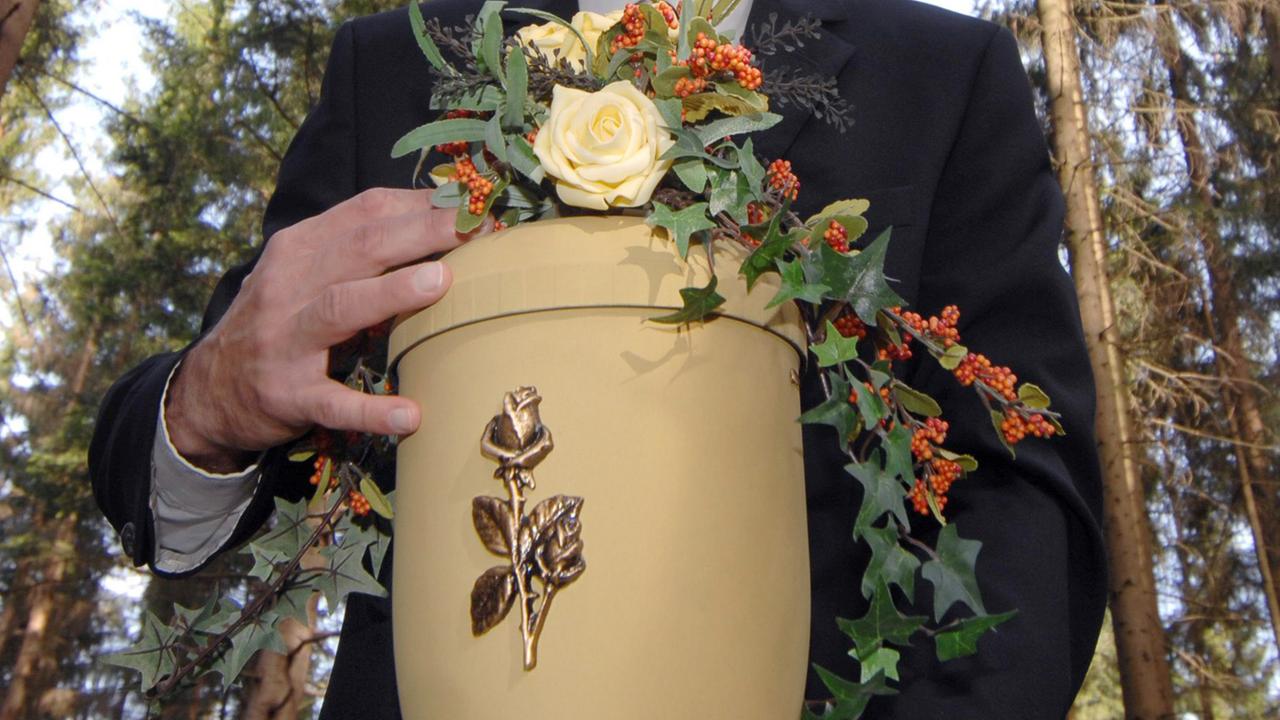 Eine Urne mit einer Rose auf der Vorderseite. Eine Urne mit einer Rose auf der Vorderseite.