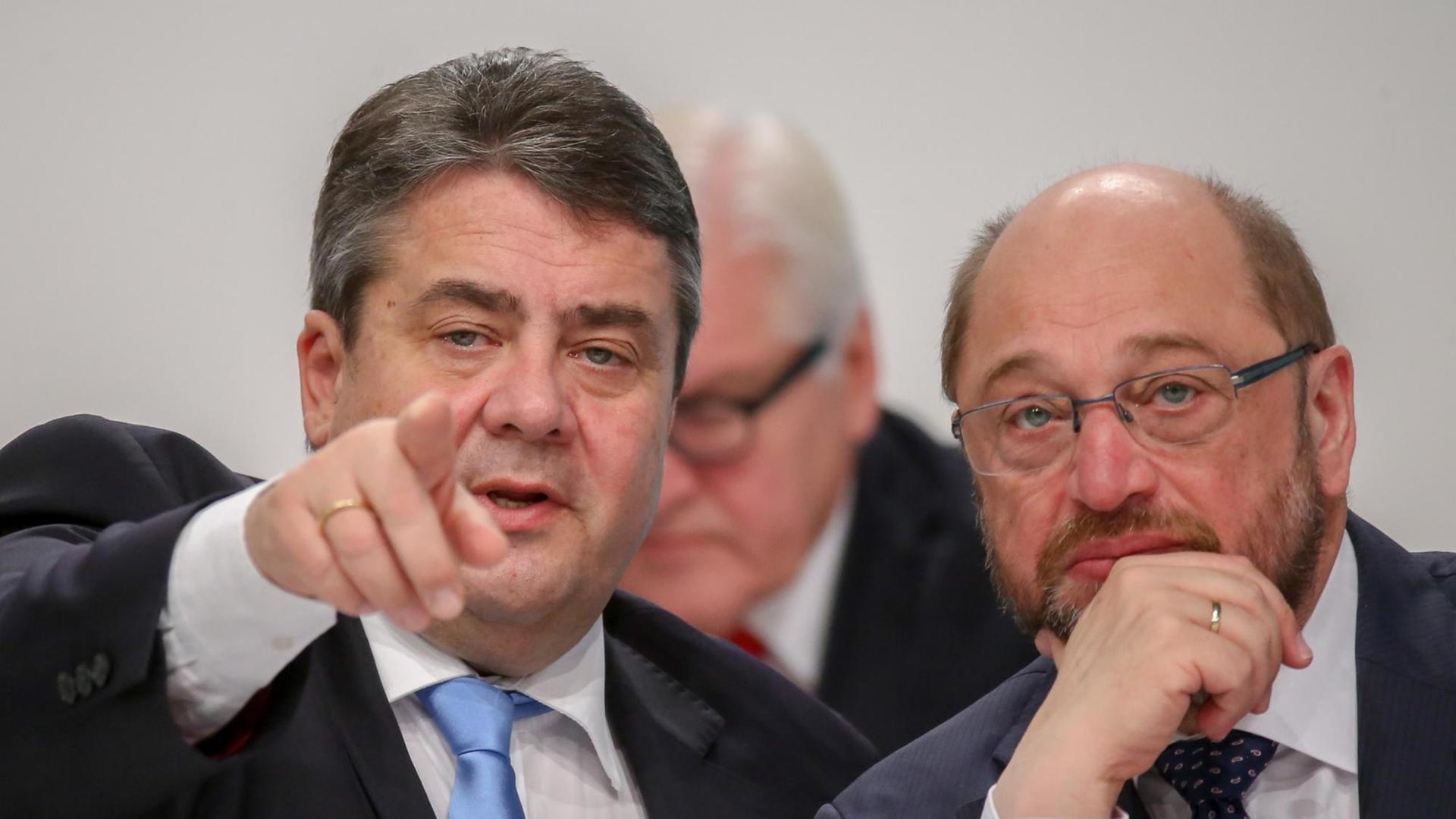 Der SPD-Vorsitzende Sigmar Gabriel spricht mit EU Parlamentspräsident Martin Schulz (SPD, r) am 12.12.2015 beim Bundesparteitag der Sozialdemokratischen Partei Deutschlands in Berlin neben der Bühne.
