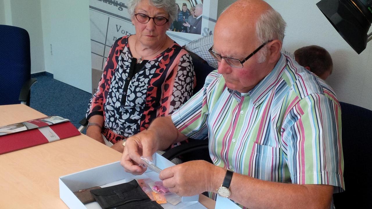 Joost und Trud de Snoo bekommen in Bad Arolsen die Hinterlassenschaften des Vaters aus der Effektenkammer des KZ Neuengamme. Joost und Trud de Snoo bekommen in Bad Arolsen die Hinterlassenschaften des Vaters aus der Effektenkammer des KZ Neuengamme.
