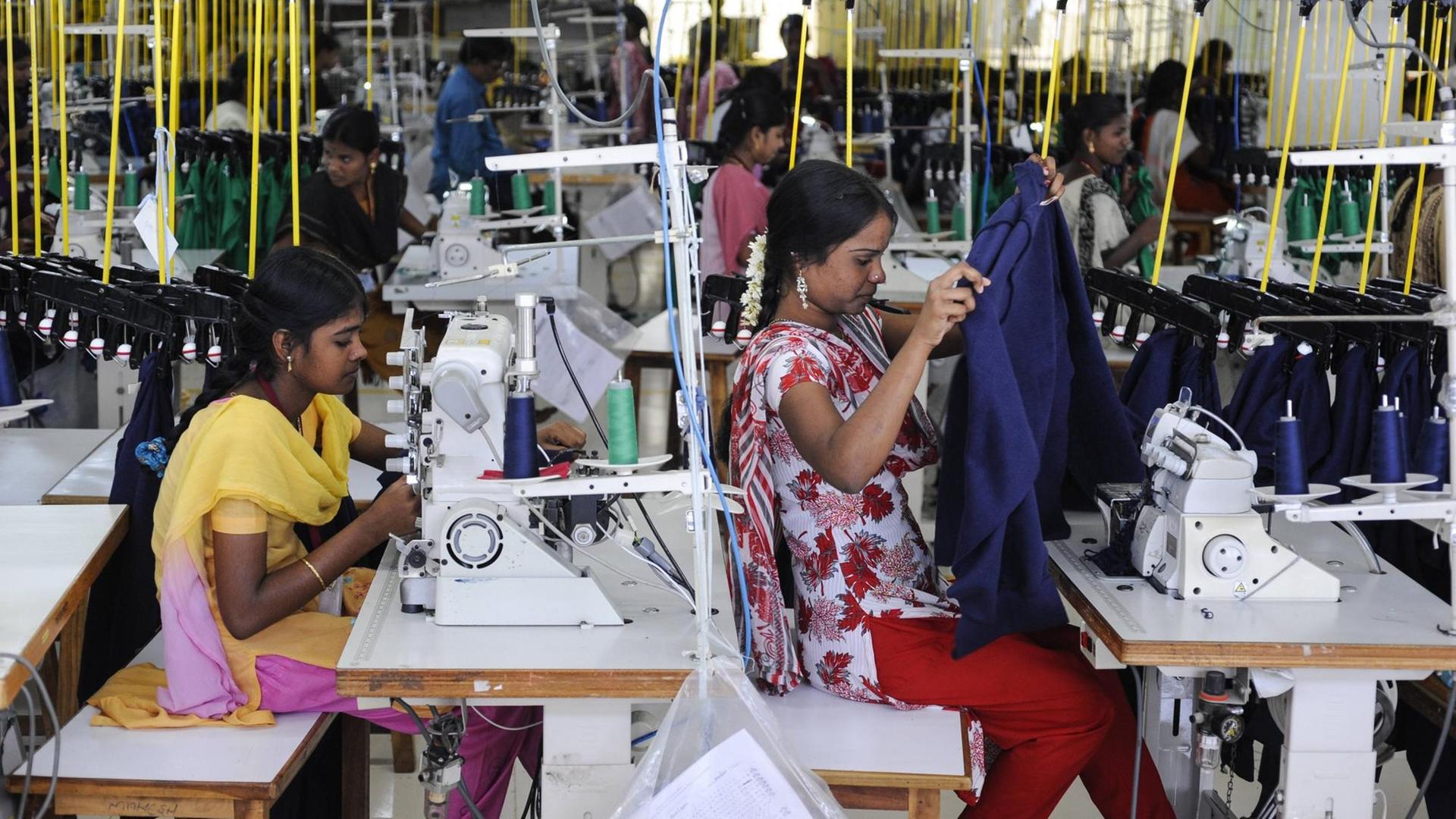Arbeiterinnen in einer Textilfabrik in Indien, die Fair-Trade-Kleidung produiziert Arbeiterinnen in einer Textilfabrik in Indien, die Fair-Trade-Kleidung produiziert