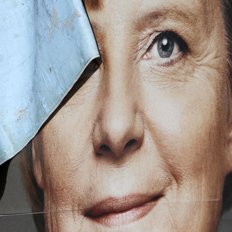 Das Bild zeigt ein kaputtes Wahlplakat von Angela Merkel.