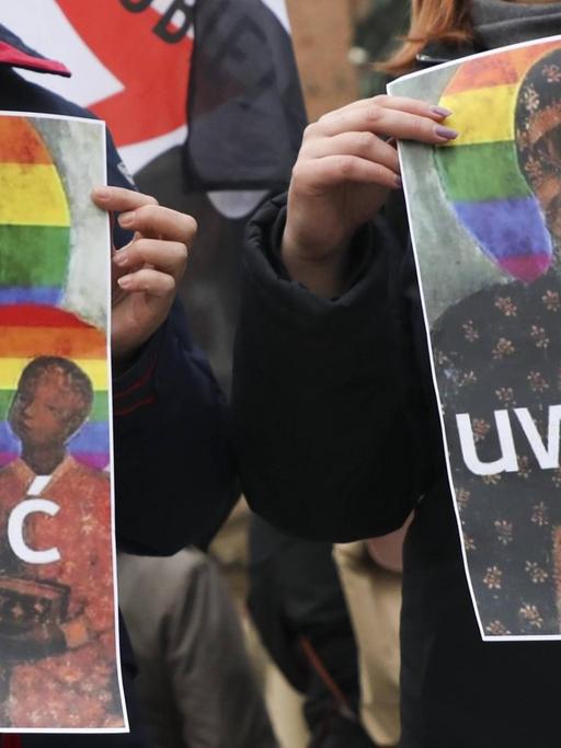 Zwei Plakate zeigen die Schwarze Madonna von Tschenstochau. Statt des goldenen Heiligenscheins trägt sie einen Heiligenschein in Regenbogenfarben.