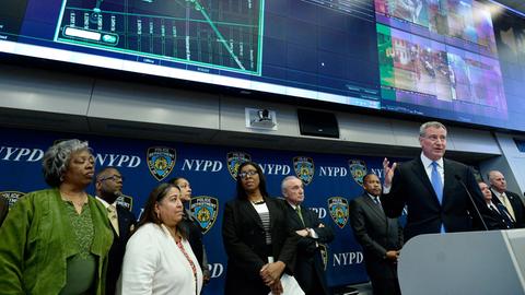 New Yorks Bürgermeister Bill de Blasio (r.) spricht auf einer Pressekonferenz über das neue akustische Überwachungssystem "ShotSpotter". Um ihn herum stehen unter anderem Polizeibeamte.