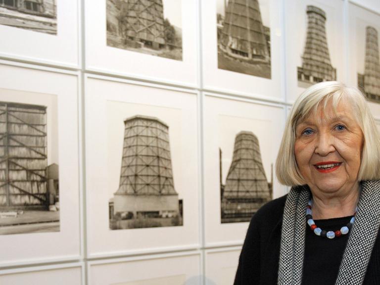 Die Fotografin Hilla Becher steht vor ihrer Fotoserie "Kühltürme".
