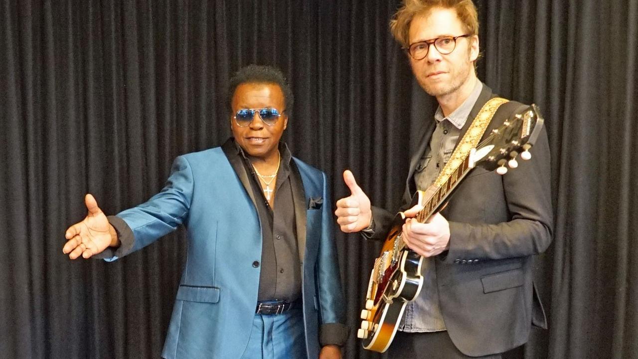 Lee Fields mit blauem Anzug und sein Musikerkollege mit Gitarre im Studio Lee Fields mit blauem Anzug und sein Musikerkollege mit Gitarre im Studio