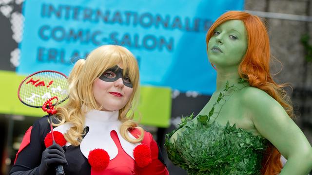 Die Figuren aus dem Batman-Comic Harley Quinn (l.) und Poisin Ivy stehen am 19.06.2014 in Erlangen vor dem Eingang des 16. Internationalen Comic-Salons.