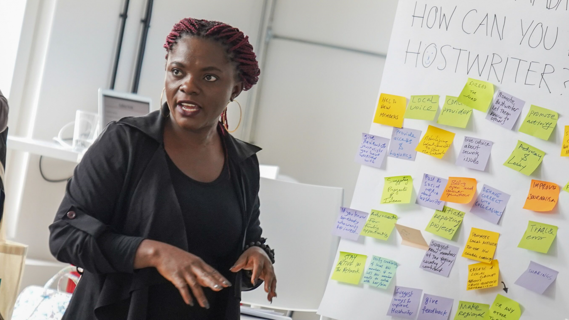 Eine Frau steht vor einem Message-Board, auf dem "How can you Hostwriter?" steht. Eine Frau steht vor einem Message-Board, auf dem "How can you Hostwriter?" steht.