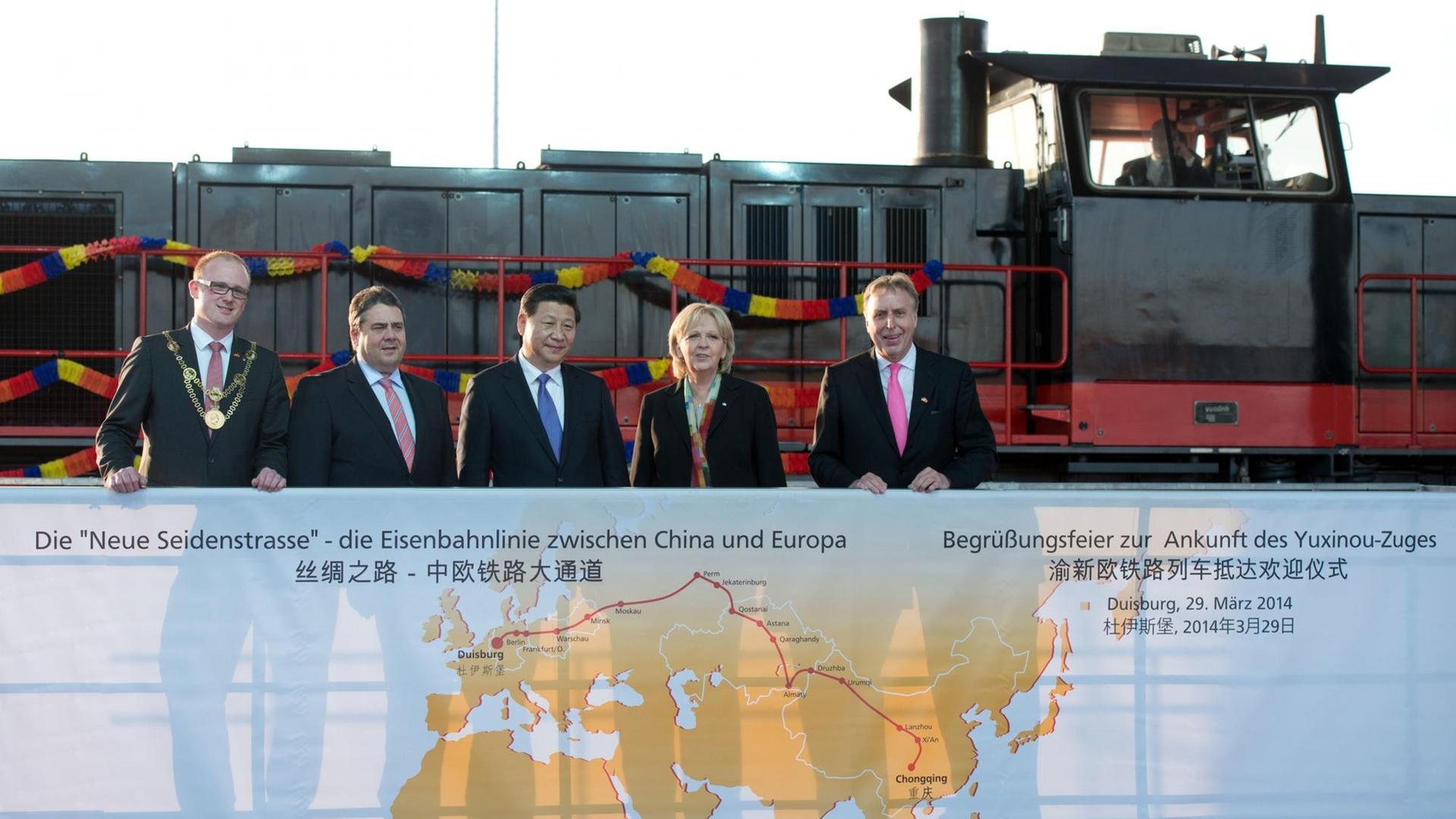 Chinas Staats- und Parteichef Xi Jinping (Mitte) steht am 29.03.2014 in Duisburg zwischen Duisburgs Oberbürgermeister Sören Link, Bundeswirtschaftsminister Sigmar Gabriel, NRW-Ministerpräsidentin Hannelore Kraft und Erich Staake, Geschäftsführer des Duisburger Hafens Logport (l-r) vor dem gerade eingefahrenen Yuxinou-Zug. Chinas Staats- und Parteichef Xi Jinping (Mitte) steht am 29.03.2014 in Duisburg zwischen Duisburgs Oberbürgermeister Sören Link, Bundeswirtschaftsminister Sigmar Gabriel, NRW-Ministerpräsidentin Hannelore Kraft und Erich Staake, Geschäftsführer des Duisburger Hafens Logport (l-r) vor dem gerade eingefahrenen Yuxinou-Zug.