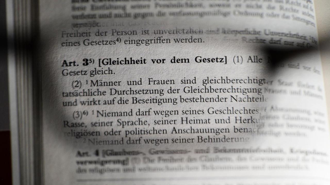 Der Artikel 3 des Grundgesetzes über Gleichheit vor dem Gesetz, fotografiert am 04.11.2015 in Berlin durch eine Brille. Foto: Jens Kalaene/dpa | Verwendung weltweit Der Artikel 3 des Grundgesetzes über Gleichheit vor dem Gesetz, fotografiert am 04.11.2015 in Berlin durch eine Brille. Foto: Jens Kalaene/dpa | Verwendung weltweit