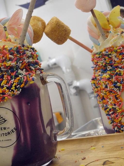 Zwei Milchshakes namens "Unicorn Parade" in einem Cafe in New York. Für die Einhorn-Optik sorgen bunte Streusel am Glasrand und eine lilafarbene, als Ube bekannte Paste aus pürierten Süßkartoffeln. Verziert wird das Getränk mit einer regenbogenfarbenen Marshmallow-Stange und dünnen Keks-Stäbchen