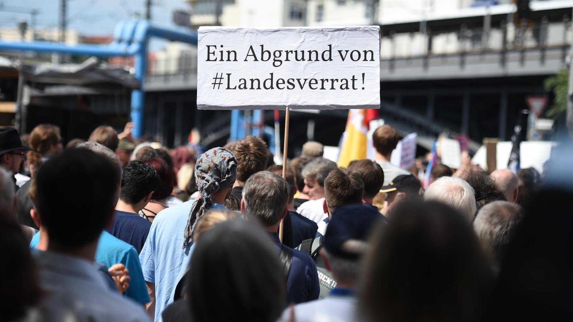 Teilnehmer einer Demonstration von Unterstützern des Internetportals Netzpolitik.org halten am 01.08.2015 in Berlin bei der Demonstration ein Schild "Ein Abgrund von #Landesverrat.!"