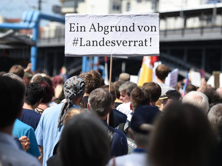 Teilnehmer einer Demonstration von Unterstützern des Internetportals Netzpolitik.org halten am 01.08.2015 in Berlin bei der Demonstration ein Schild "Ein Abgrund von #Landesverrat.!"