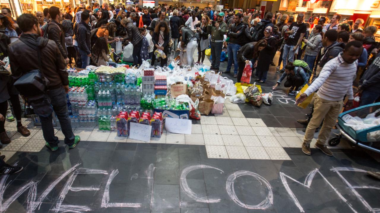 Mit einem Willkommensgruß und selbst mitgebrachten Lebensmitteln und Getränken warten am 05.09.2015 in Frankfurt am Main freiwillige Helfer im Hauptbahnhof auf die Ankunft von Flüchtlingen in der Stadt.