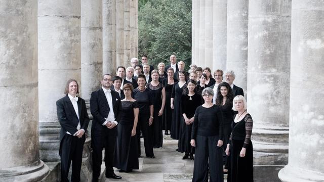 Die Musikerinnen und Musiker der Kölner Akademie stehen in einem historischen Arkadengang