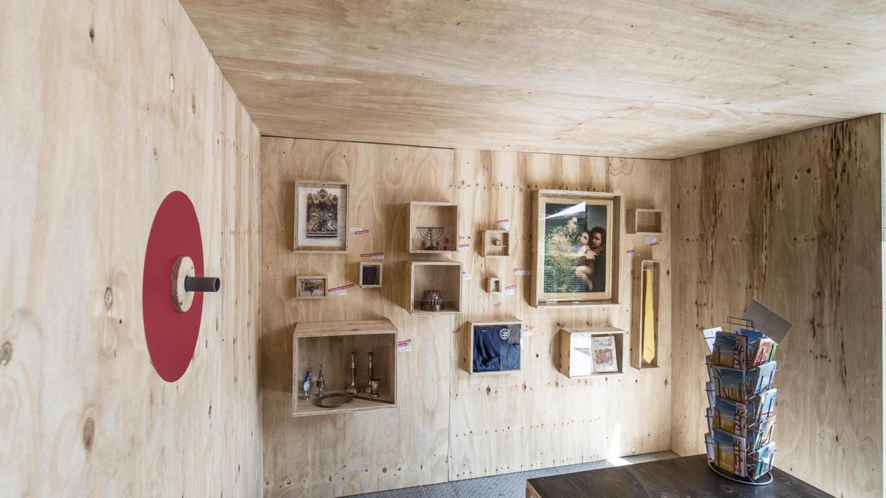 Eine Sperrholzwand mit kleinen Holzkästen und jüdischen Zeremonialobjekten. Eine Sperrholzwand mit kleinen Holzkästen und jüdischen Zeremonialobjekten.