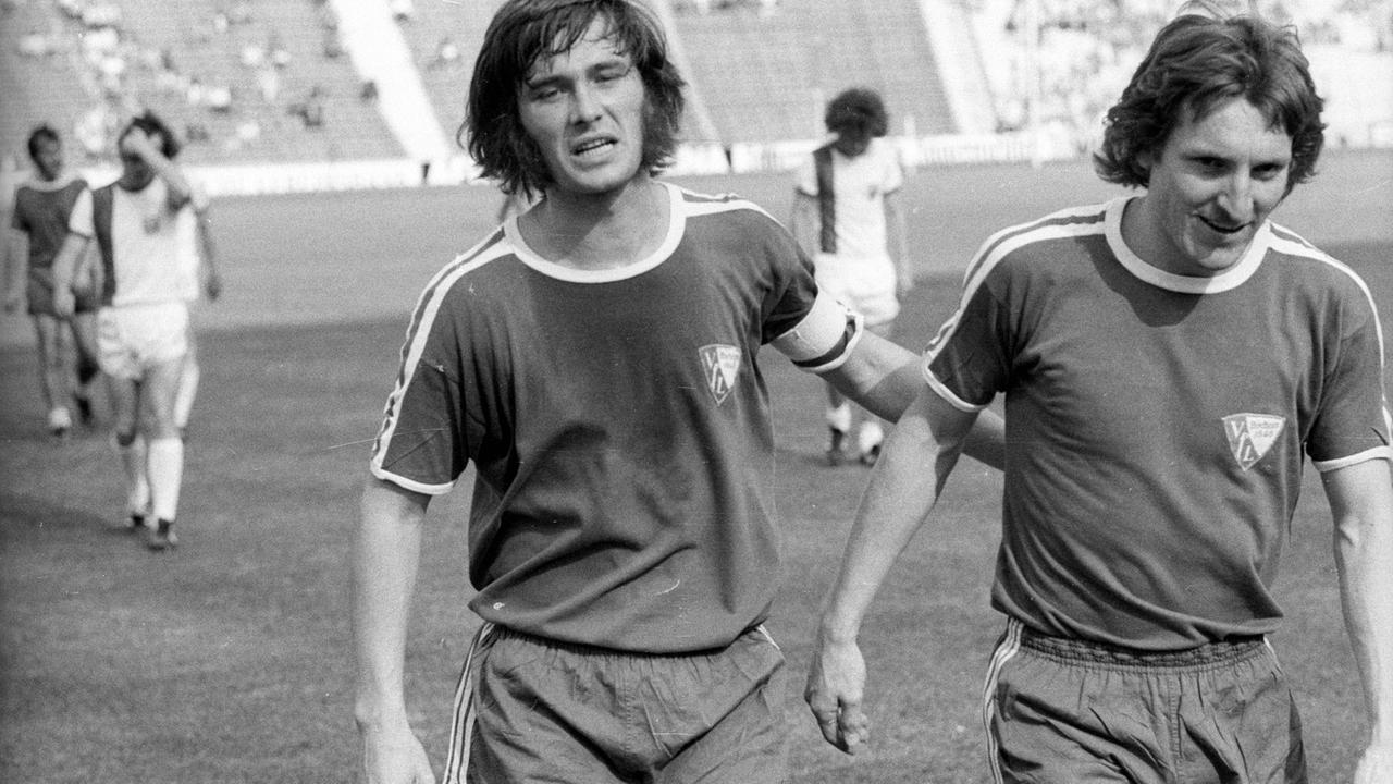 Schwarzweißfoto von Hans Walitza und Michael "Ata" Lameck, die erschöpft vom Fußballplatz gehen Schwarzweißfoto von Hans Walitza und Michael "Ata" Lameck, die erschöpft vom Fußballplatz gehen