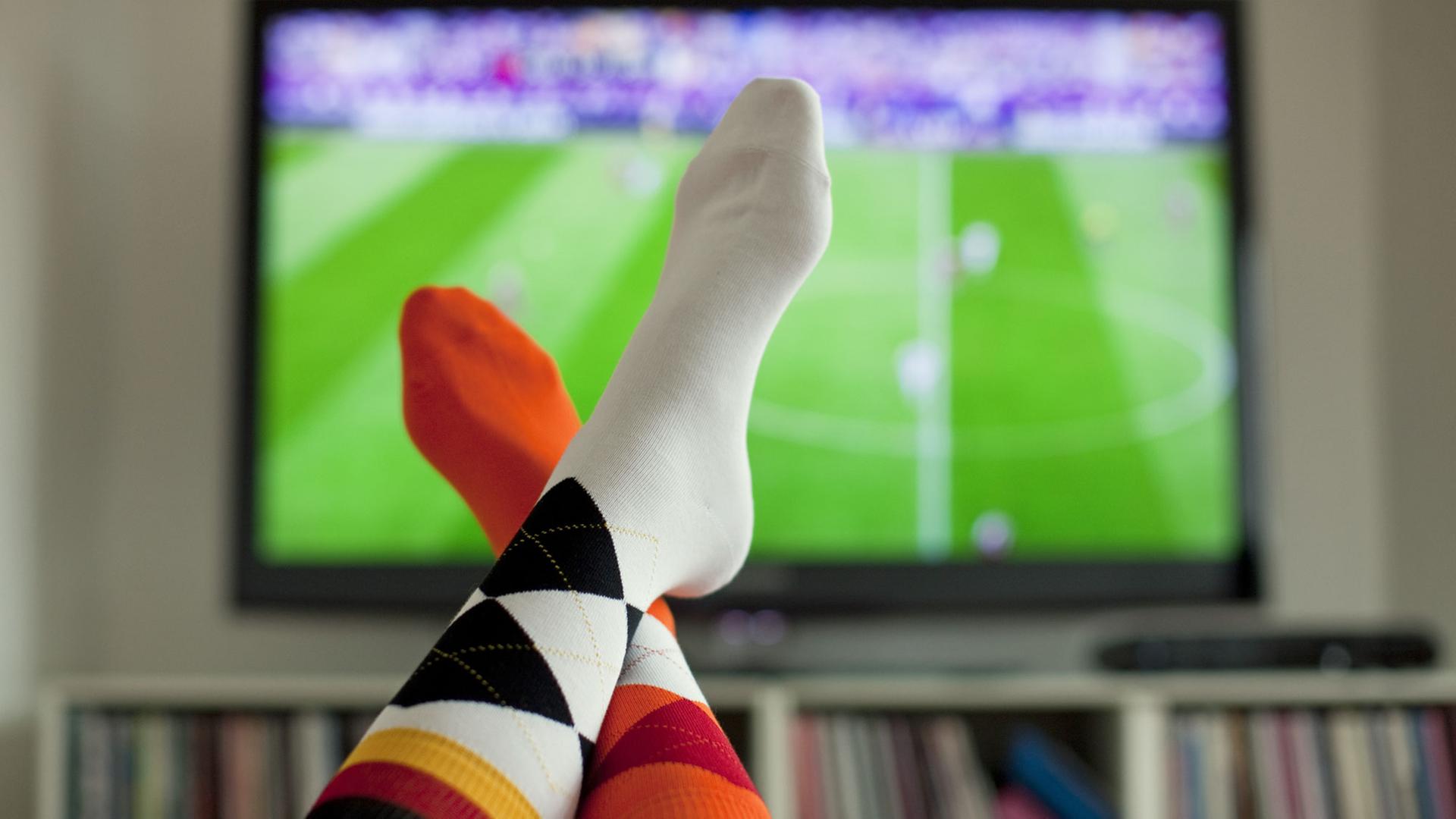 Ein junge Frau trägt am 13.06.2012 vor einem Fernseher in Köln während des EM-Spiels Dänemark gegen Portugal Socken in den Deutschlandfarben und in den Farben der Niederlande. Die deutsche Fußball-Nationalmannschaft trifft am Abend bei der EM auf die Niederlande. Ein junge Frau trägt am 13.06.2012 vor einem Fernseher in Köln während des EM-Spiels Dänemark gegen Portugal Socken in den Deutschlandfarben und in den Farben der Niederlande. Die deutsche Fußball-Nationalmannschaft trifft am Abend bei der EM auf die Niederlande.