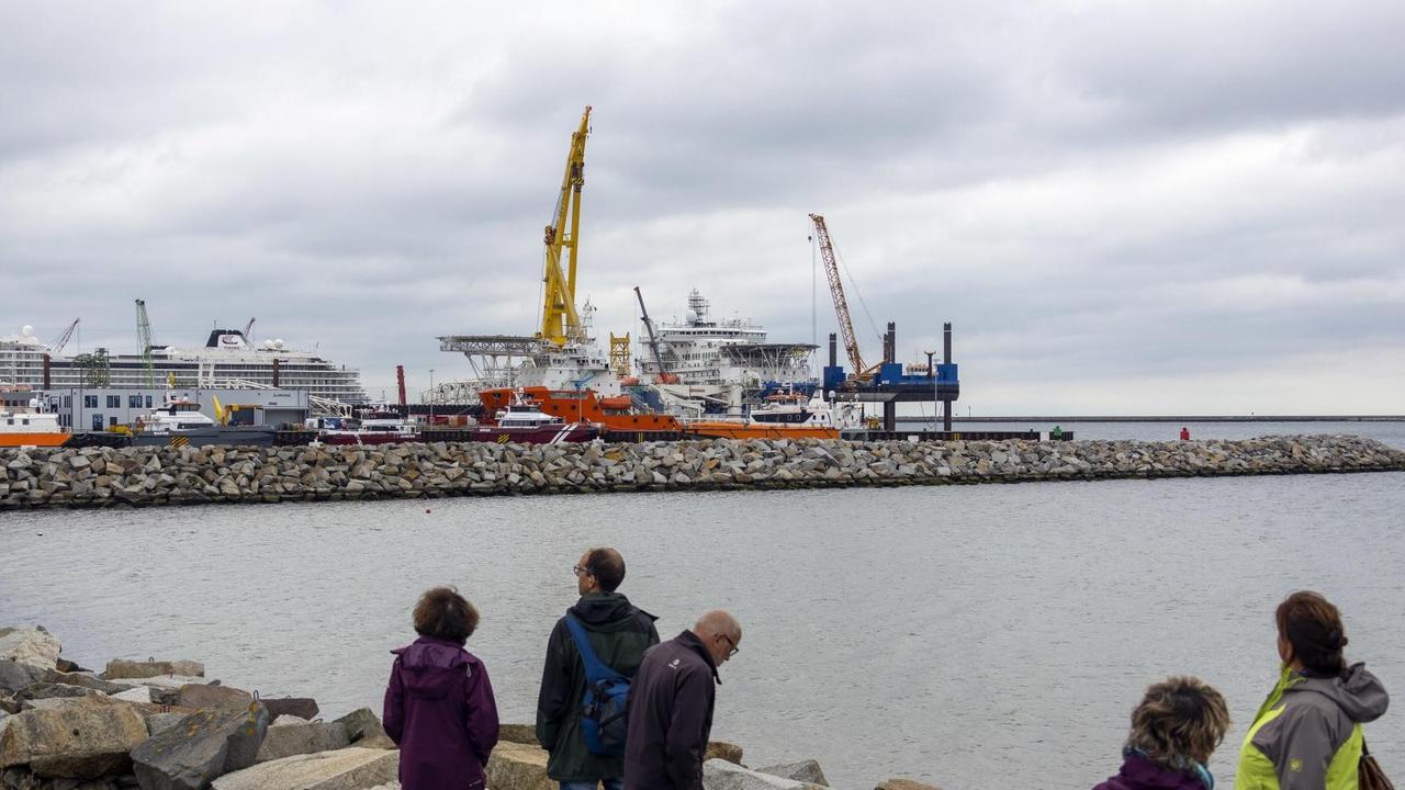 Menschen blicken auf den Fährhafen Mukran, auf dem zwei russische Schiffe für den Weiterbau der Nordstream 2 Pipeline vorbereitet werden. Menschen blicken auf den Fährhafen Mukran, auf dem zwei russische Schiffe für den Weiterbau der Nordstream 2 Pipeline vorbereitet werden.
