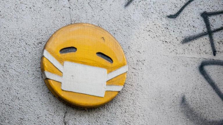 Mundschutz-Emoji an einer Wand in Mailand, fotografiert Mitte April 2020, während der weltweiten Covid-19-Pandemie