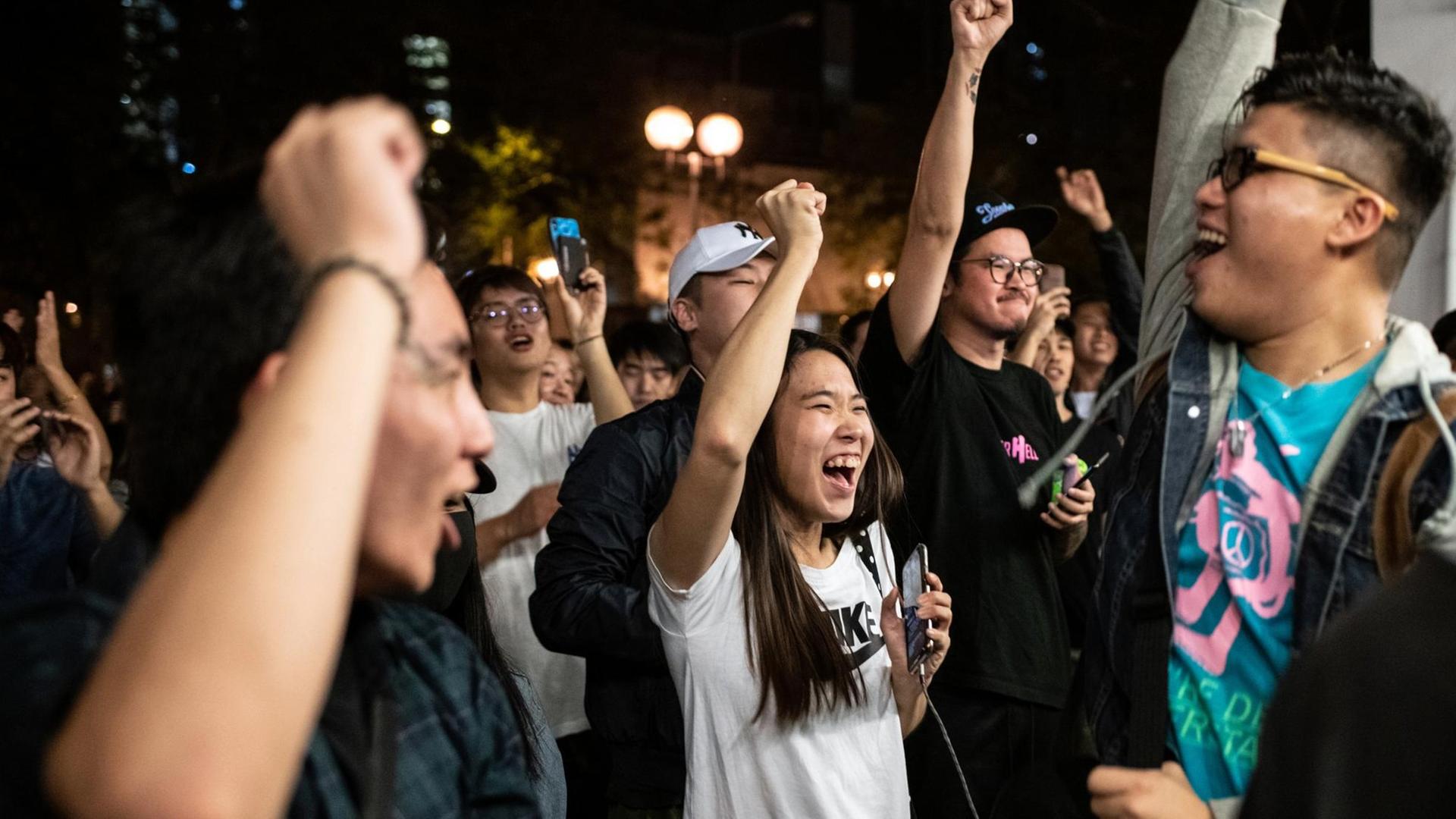 Pro-demokratische Unterstützer feiern den Sieg eines ihrer Kandidaten und recken die Fäuste in die Höhe. Pro-demokratische Unterstützer feiern den Sieg eines ihrer Kandidaten und recken die Fäuste in die Höhe.