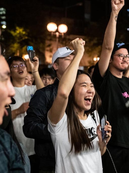 Pro-demokratische Unterstützer feiern den Sieg eines ihrer Kandidaten und recken die Fäuste in die Höhe.