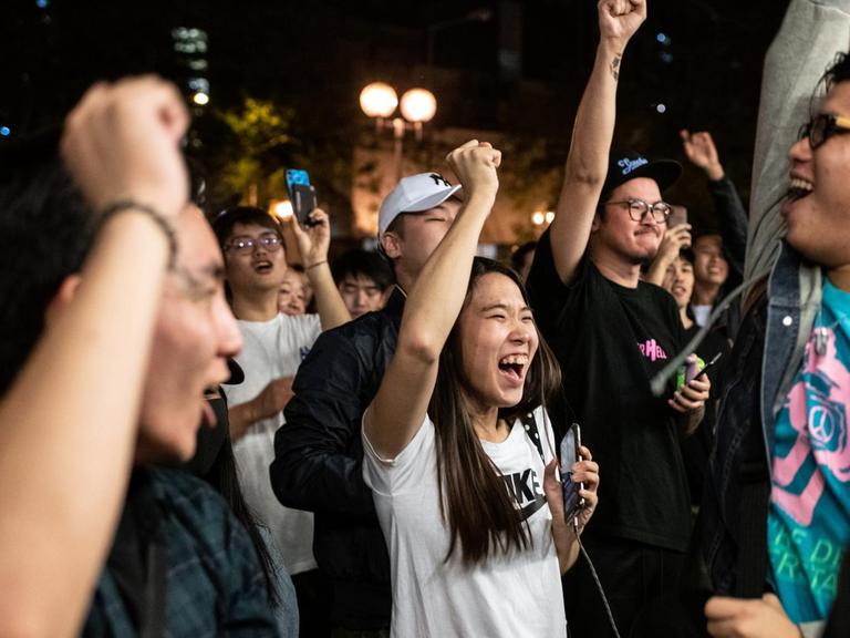 Pro-demokratische Unterstützer feiern den Sieg eines ihrer Kandidaten und recken die Fäuste in die Höhe.