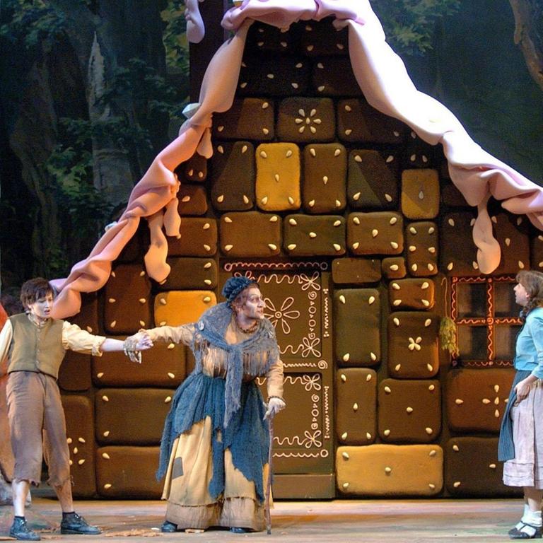Hänsel und Gretel vor dem Lebkuchenhäuschen der bösen Hexe. Ein Foto aus einer Inszenierung der Oper "Hänsel und Gretel" von Engelbert Humperdinck.