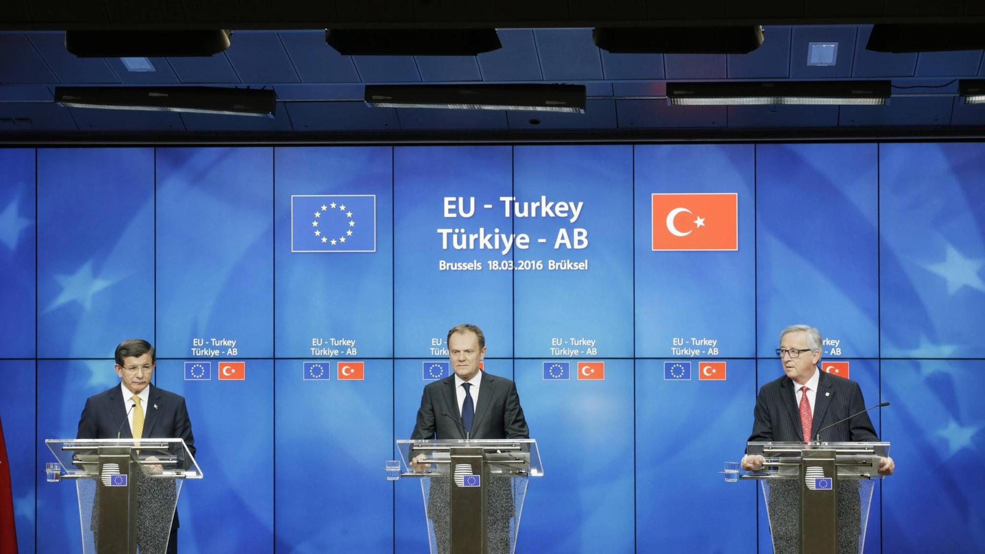 Der türkische Ministerpräsident Ahmet Davutoglu, der EU-Ratspräsident Donald Tusk und EU-Kommissionspräsident Jean-Claude Juncker präsentieren in Brüssel das gemeinsame Flüchtlingsabkommen. Der türkische Ministerpräsident Ahmet Davutoglu, der EU-Ratspräsident Donald Tusk und EU-Kommissionspräsident Jean-Claude Juncker präsentieren in Brüssel das gemeinsame Flüchtlingsabkommen.