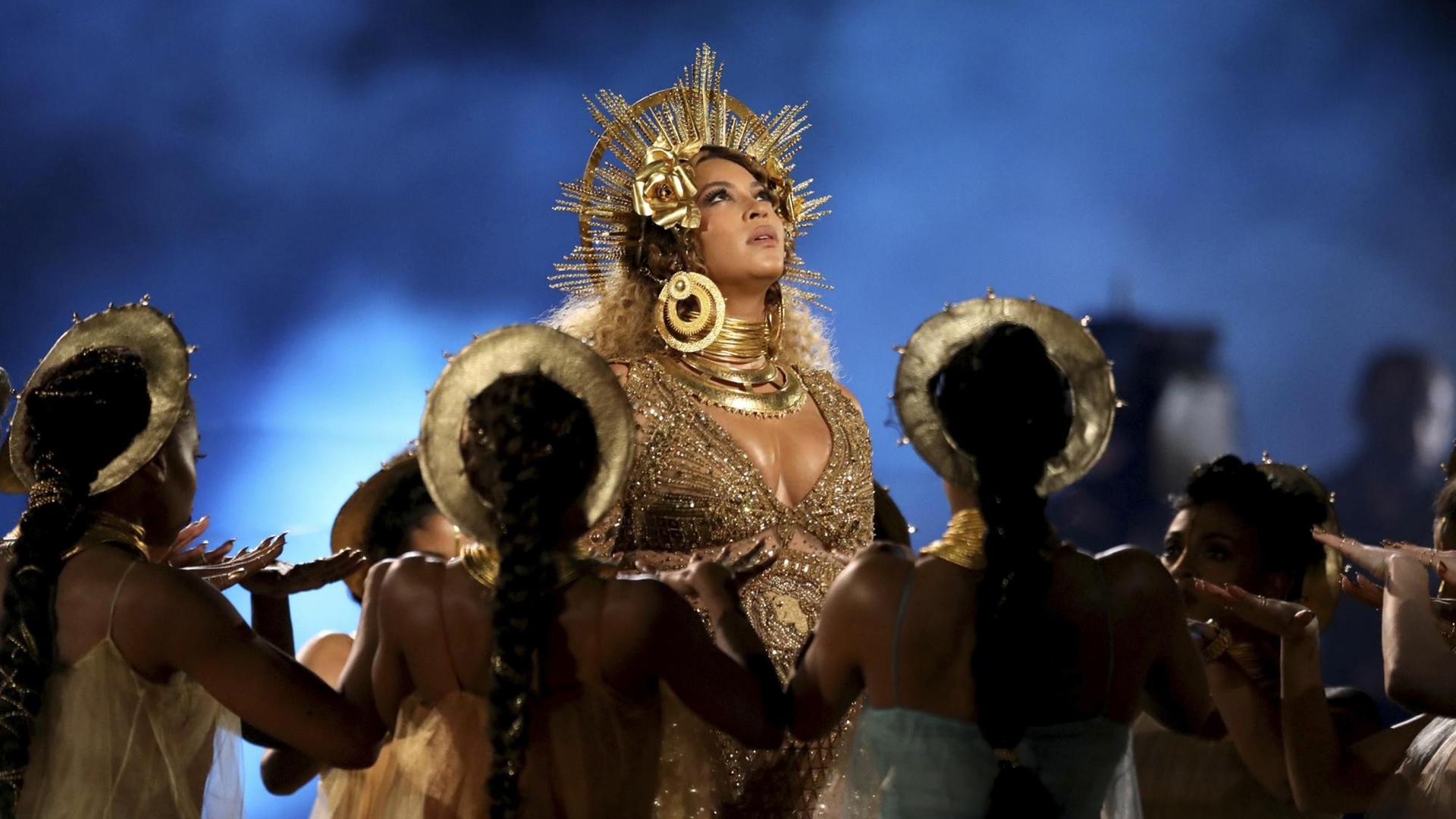 Beyoncé stilisiert sich zur Heiligenikone und ist dabei umringt von Tänzerinnen und Tänzern. Beyoncé stilisiert sich zur Heiligenikone und ist dabei umringt von Tänzerinnen und Tänzern.