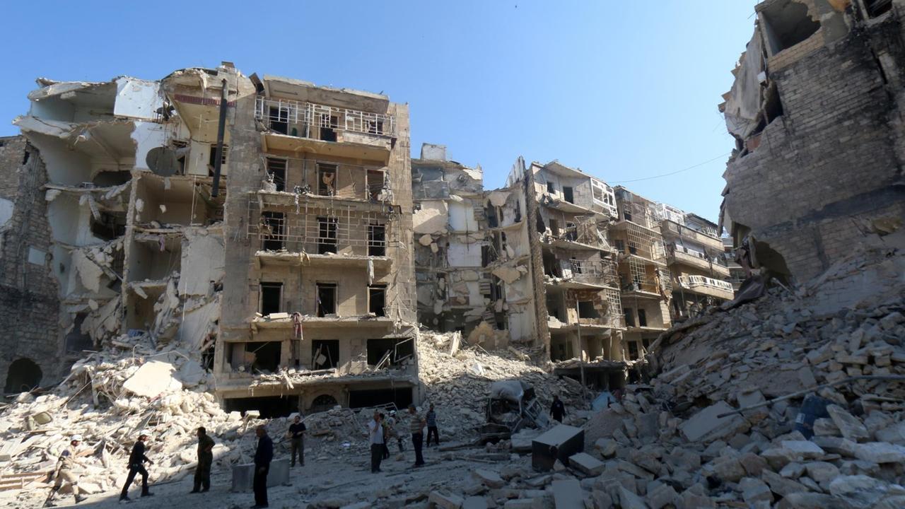 Menschen stehen vor zerstörten Häusern in der syrischen Stadt Aleppo Menschen stehen vor zerstörten Häusern in der syrischen Stadt Aleppo