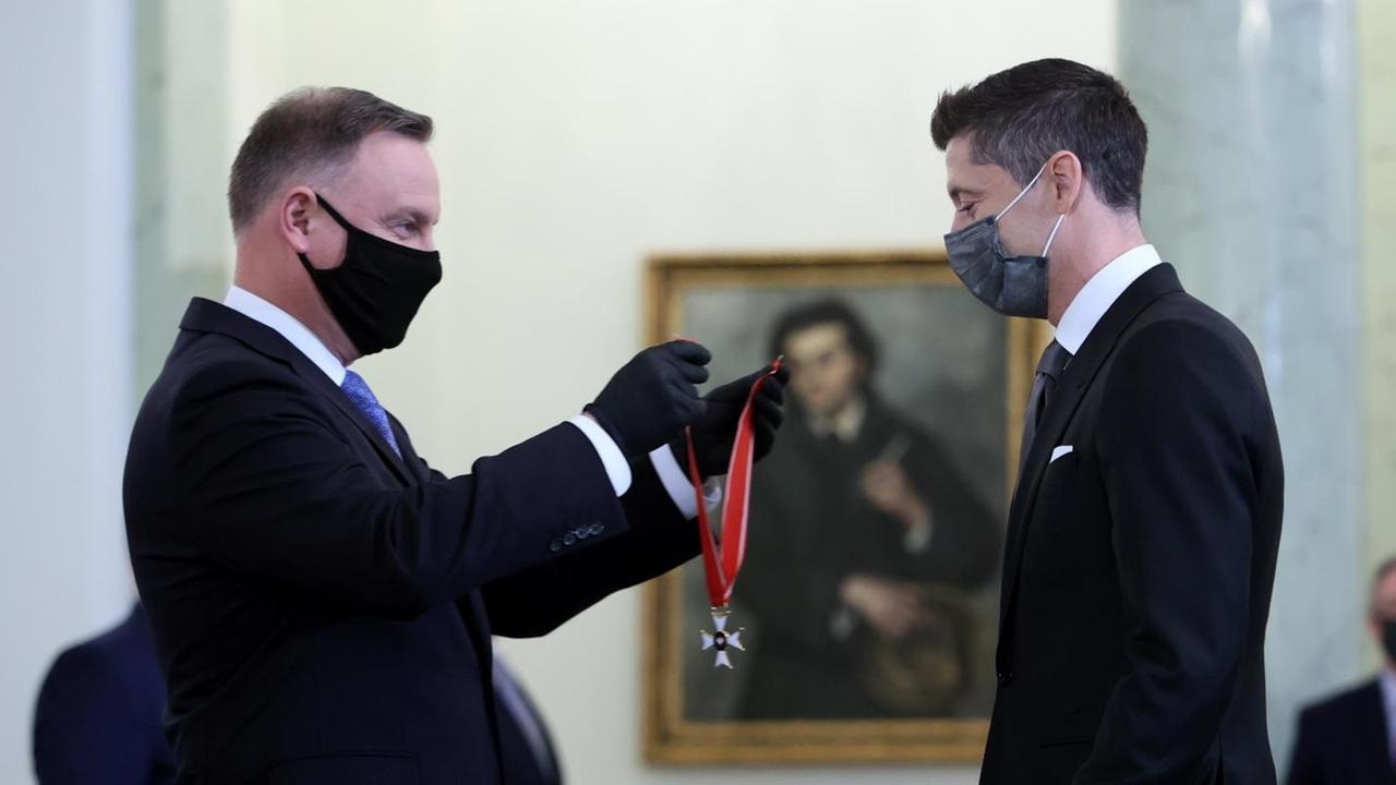 Duda geht mit dem Orden in der Hand auf Lewandowski zu. Duda geht mit dem Orden in der Hand auf Lewandowski zu.