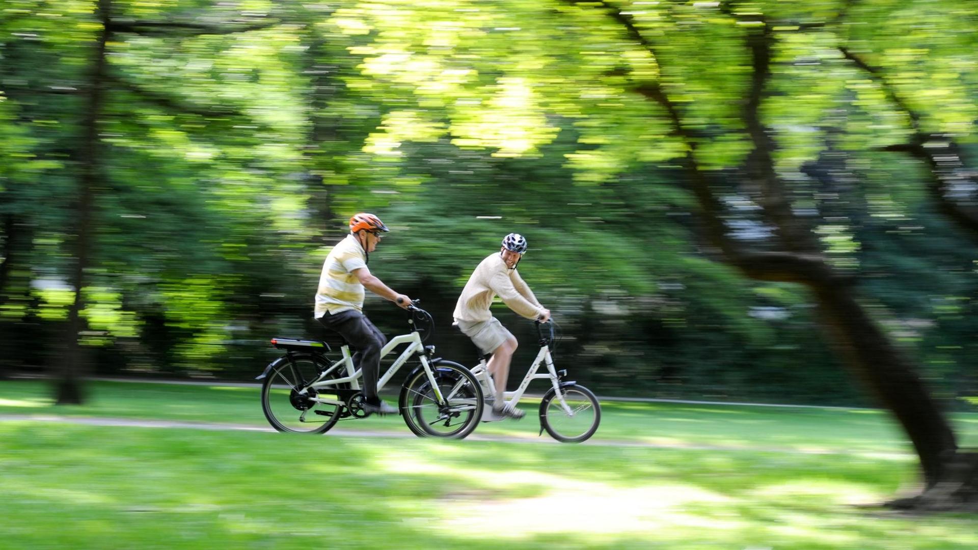 Zwei Männer fahren in München (Bayern) auf ihren Pedelecs Zwei Männer fahren in München (Bayern) auf ihren Pedelecs