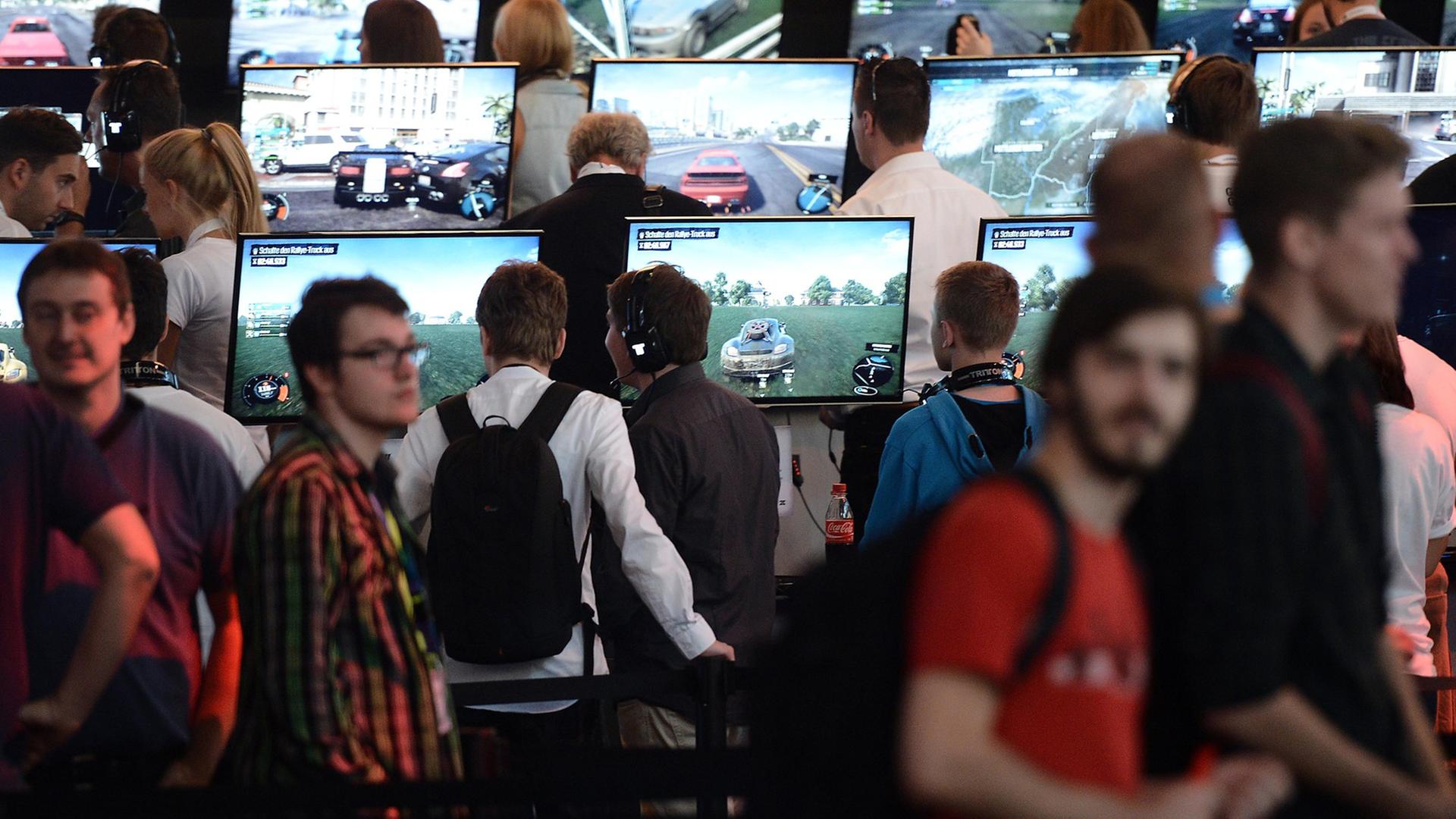 Besucher spielen am 13.08.2014 in Köln (Nordrhein-Westfalen) am Fachbesuchertag der Computerspielemesse "Gamescom" das Spiels "The Crew".