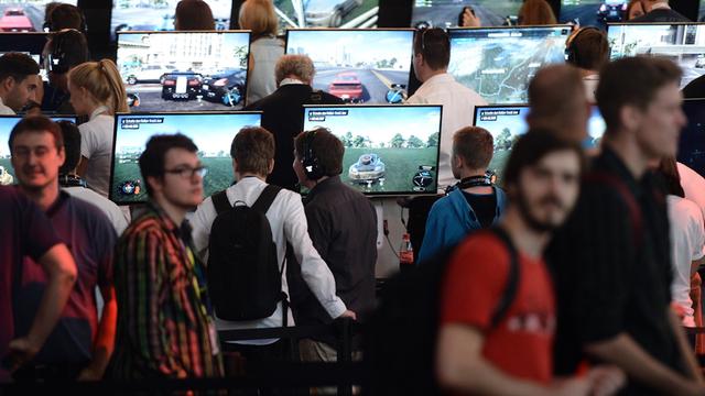 Besucher spielen in Köln am Fachbesuchertag der Computerspielemesse "Gamescom" das Spiels "The Crew".