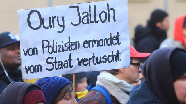 Während der Demonstration zum zehnten Todestag des Asylbewerbers Oury Jalloh in Dessau-Roßlau ein Schild mit der Aufschrift "Oury Jalloh von Polizisten ermordet vom Staat vertuscht" getragen.
