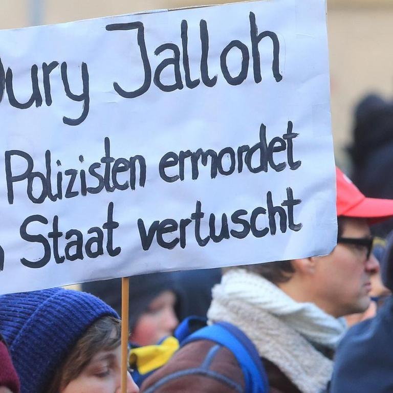 Während der Demonstration zum zehnten Todestag des Asylbewerbers Oury Jalloh in Dessau-Roßlau ein Schild mit der Aufschrift "Oury Jalloh von Polizisten ermordet vom Staat vertuscht" getragen. 