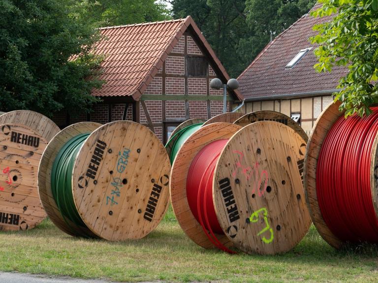 Verschiedene Kabeltrommel stehen vor Fachwerkhäusern.