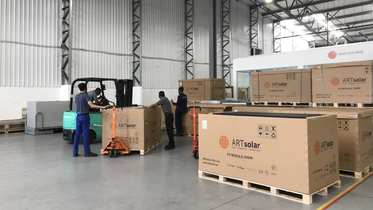 Mitarbeiter bereiten die Solarmodule für den Transport vor. Mitarbeiter bereiten die Solarmodule für den Transport vor.