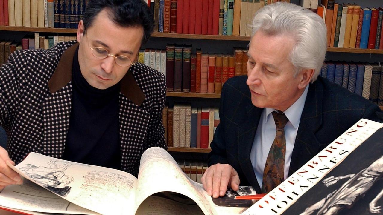 Die beiden Verleger Elmar (r) und Michael Faber vom Verlag "Faber & Faber" Leipzig betrachten am 17.03.2003 das illustrierte Buch "Offenbarung des Johannes" mit Grafiken des Berliner Künstlers Volker Stelzmann, das auf der Leipziger Buchmesse 2003 am Stand des Verlages zu sehen ist. Die beiden Verleger Elmar (r) und Michael Faber vom Verlag "Faber & Faber" Leipzig betrachten am 17.03.2003 das illustrierte Buch "Offenbarung des Johannes" mit Grafiken des Berliner Künstlers Volker Stelzmann, das auf der Leipziger Buchmesse 2003 am Stand des Verlages zu sehen ist.