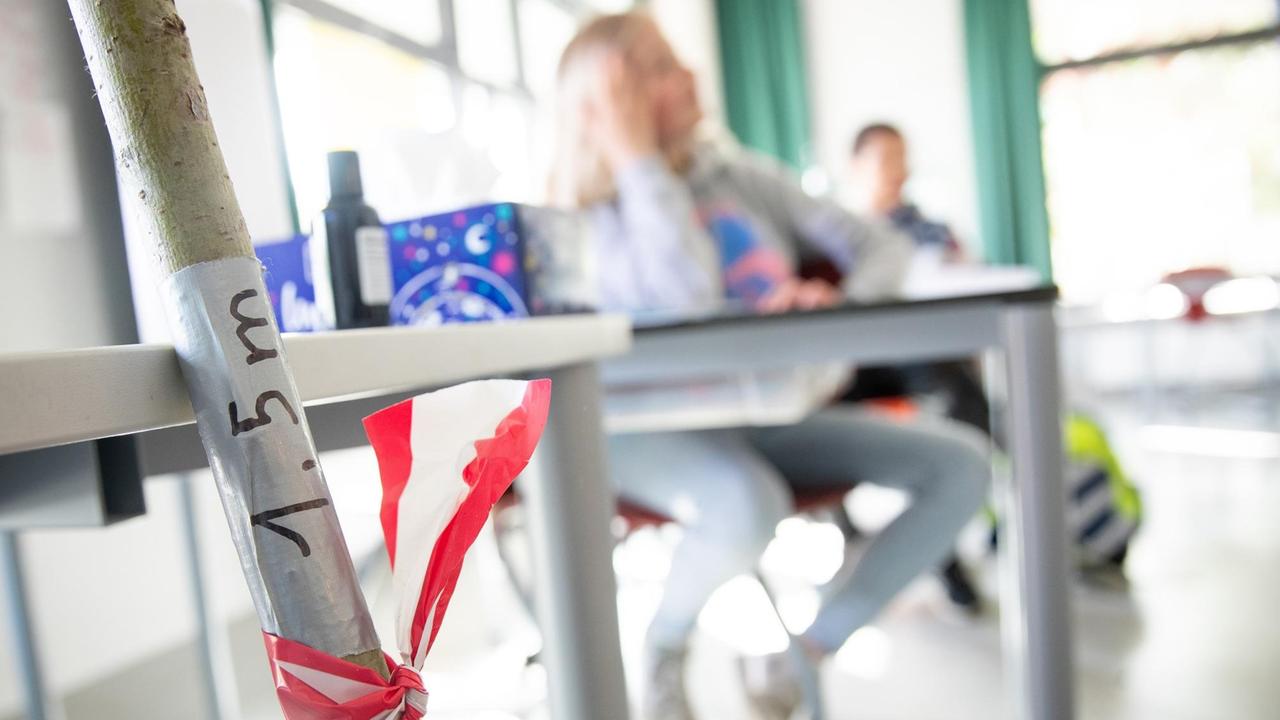 In einer Hamburger Grundschule wird in einem Klassenzimmer mit einem Aufkleber auf einen Abstand von 1,5 Metern hingewiesen.
