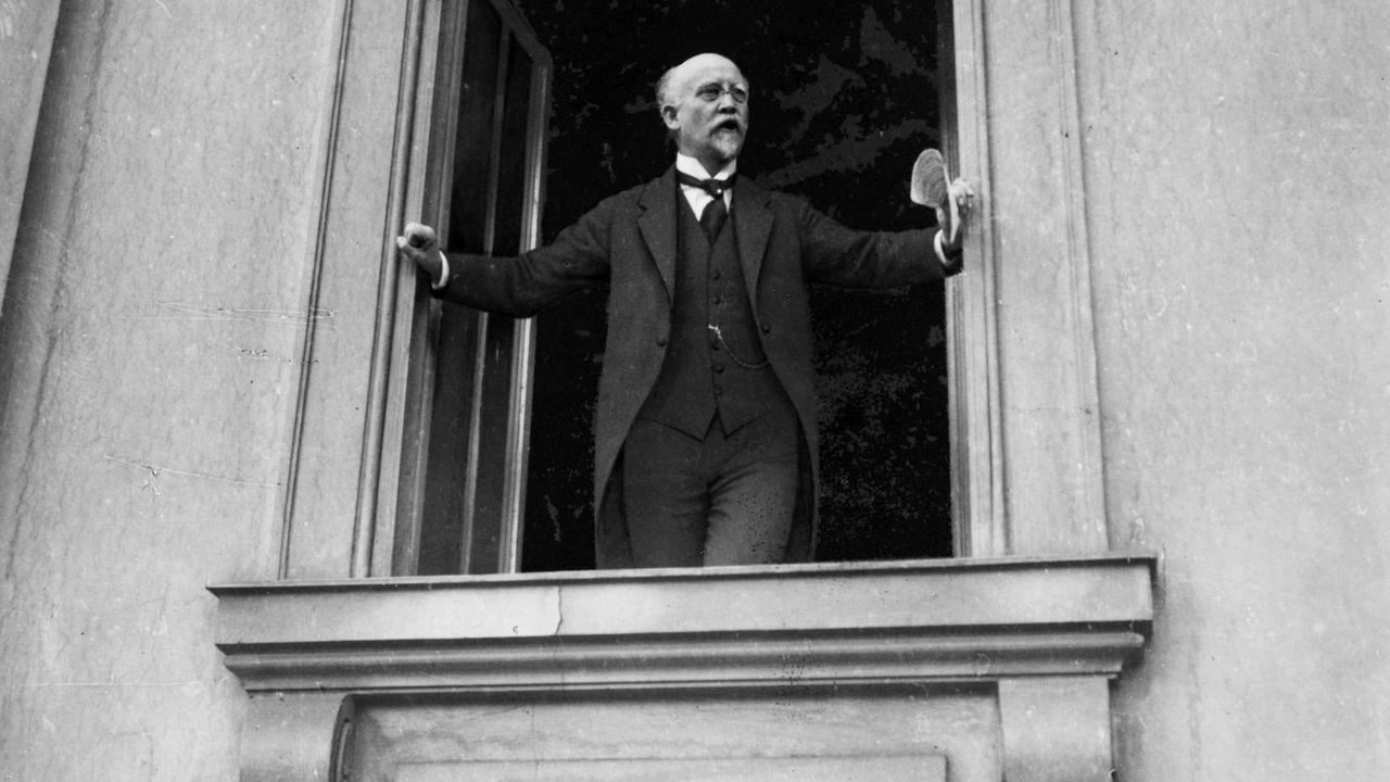 Philipp Scheidemann steht an einem Fenster und richtet sich an eine im Bild nicht sichtbare Masse. Philipp Scheidemann steht an einem Fenster und richtet sich an eine im Bild nicht sichtbare Masse.