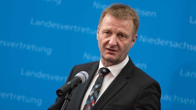 NRW-Innenminister Ralf Jäger (SPD) steht mit geballten Fäusten vor einem Mikrofon