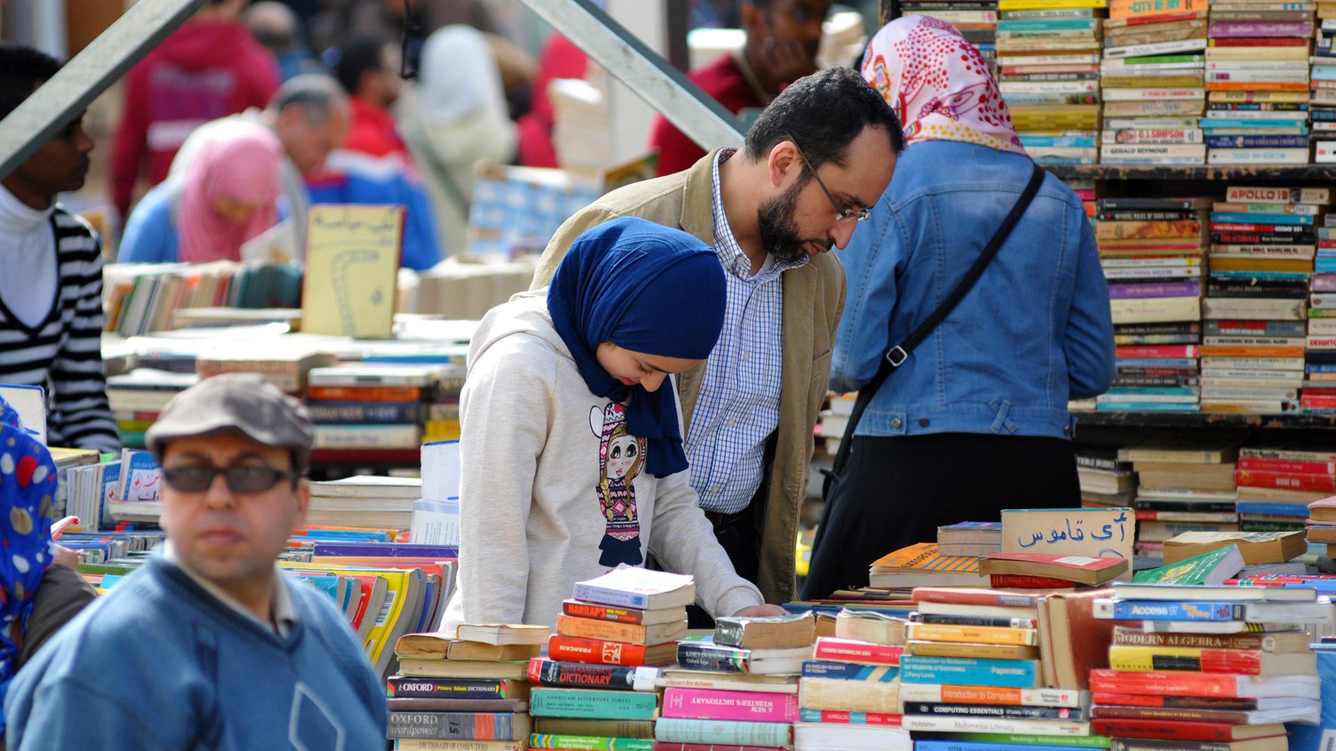 Ägyptische Besucher auf der Buchmesse in Kairo an einem Stand für gebrauchte Bücher Ägyptische Besucher auf der Buchmesse in Kairo an einem Stand für gebrauchte Bücher