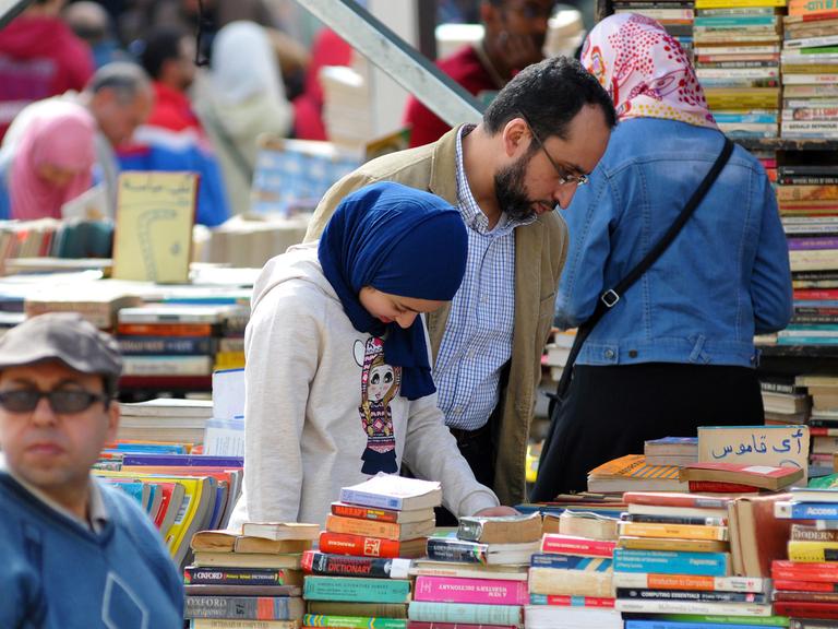 Ägyptische Besucher auf der Buchmesse in Kairo an einem Stand für gebrauchte Bücher