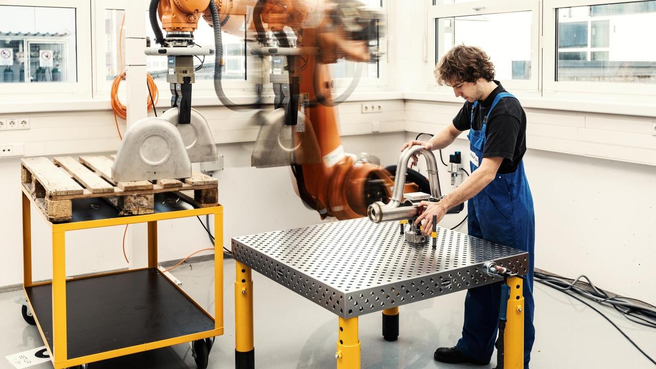 Mensch und Maschine arbeiten Hand in Hand: Der Industrieroboter im Future Work Lab in Stuttgart reicht dem Arbeiter ein Bauteil. Mensch und Maschine arbeiten Hand in Hand: Der Industrieroboter im Future Work Lab in Stuttgart reicht dem Arbeiter ein Bauteil.
